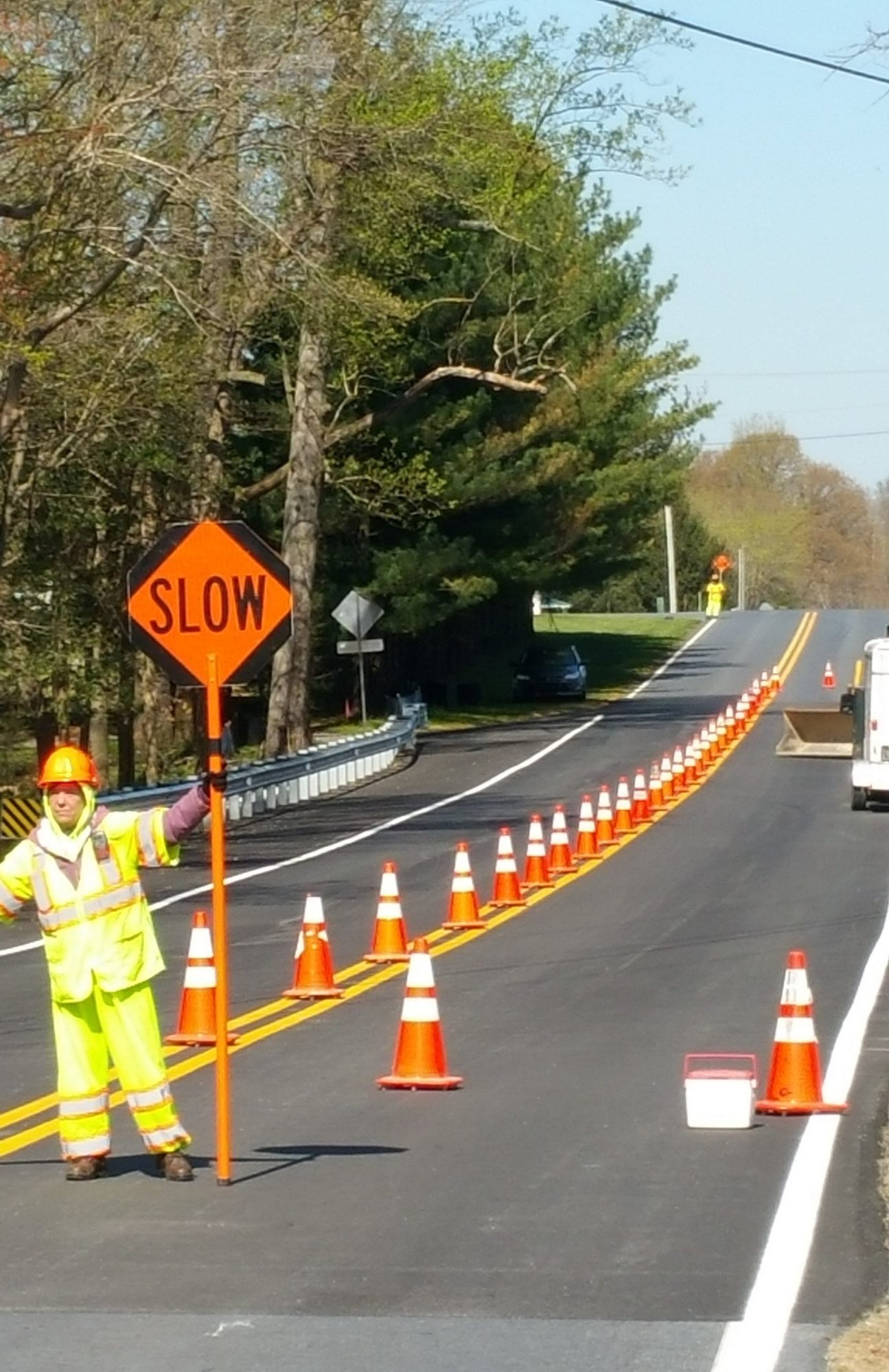 ATSSA-certified highway flagger directing traffic with MUTCD-compliant cones and signage