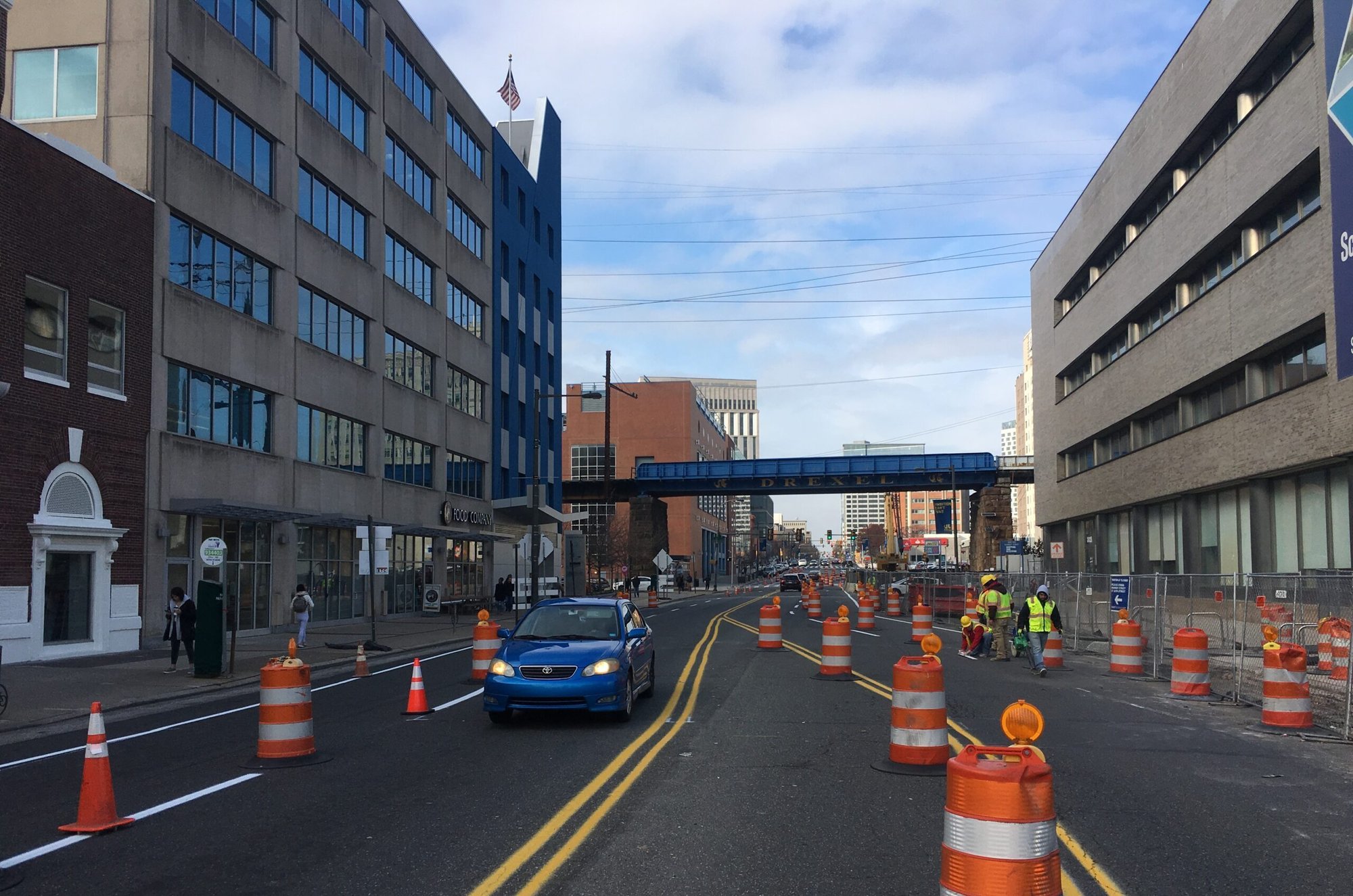 City street construction work zone with traffic barrels, safety crews, and controlled traffic flow provided by professional work zone specialists